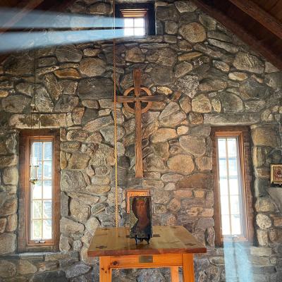 Trinity Retreat Center stone chapel is shown with light streaming in the windows