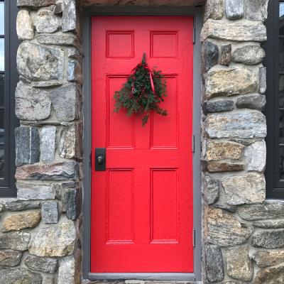 Red door on the side of the Chapel, decorated with Christmas greenery