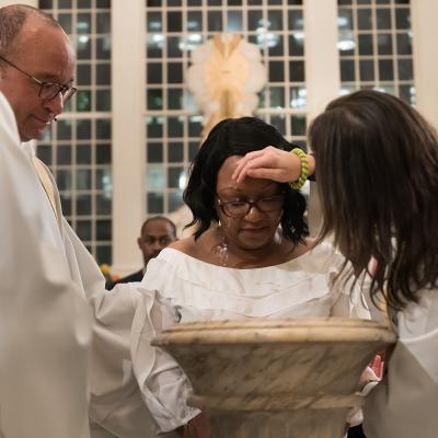 Priest baptizing woman