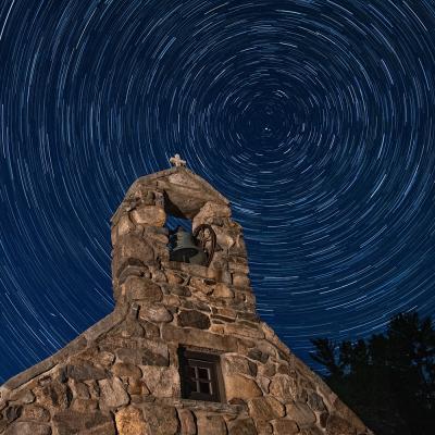 A long exposure image of a star-filled sky above the chapel at Trinity Retreat Center