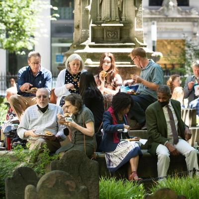 A group of parishioners enjoy lunch on the steps of the Soldiers' Monument in the northeast corner of Trinity Churchyard during a Spring 2022 Celebration.