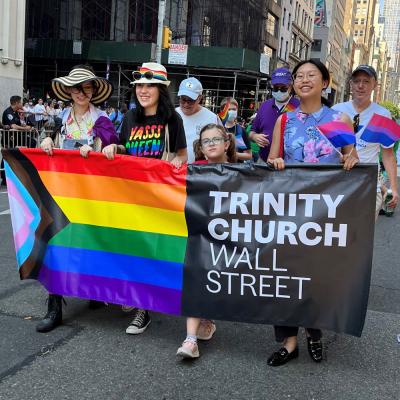 Four members of the Trinity community carry a banner in the annual NYC Pride March.