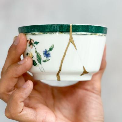 A broken white with floral decoration cup mended with gold