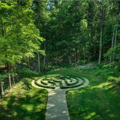 A green forest around a garden labyrinth at the Trinity Retreat Center