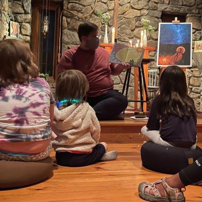 Father Matt reads a book to children in the TRC chapel