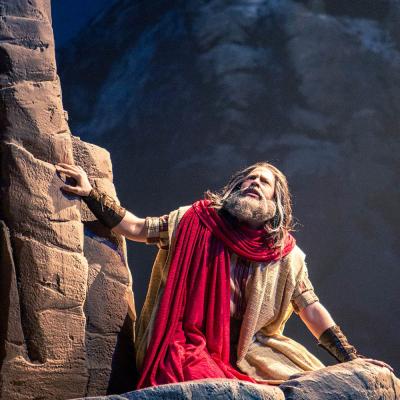 A production still of Moses kneeling on a mountaintop