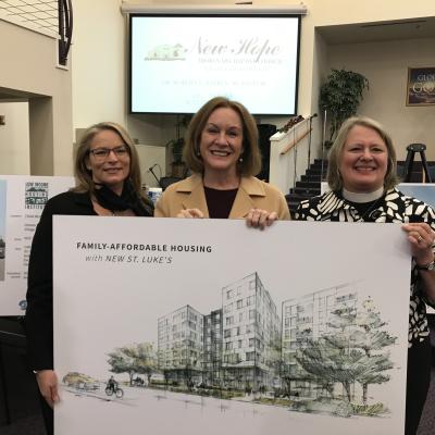Members of St. Luke’s Episcopal Church hold the rendering of the new buildings that will be built on St. Luke’s property.