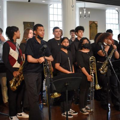 Young people stand with instruments and mic stands after a performance.