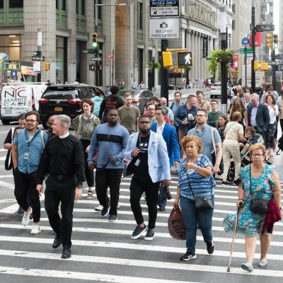 A group of the 2022 Trinity Leadership Fellows cross the street at Broadway with Fr. Bird.