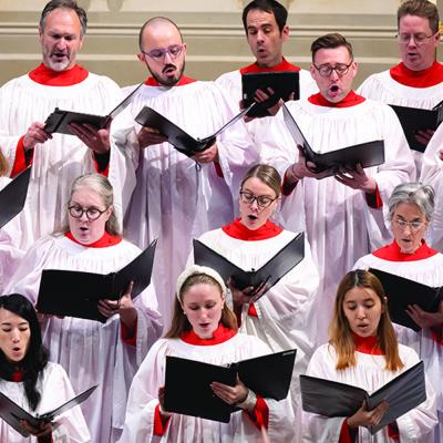 Several choir members in robes sing