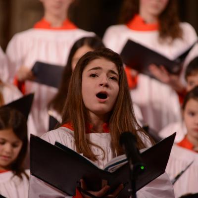 Soloist from the Trinity Youth Chorus sings with a book