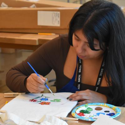 Trinity Church Wall Street staff engage in art project by creatively painting tote bags.