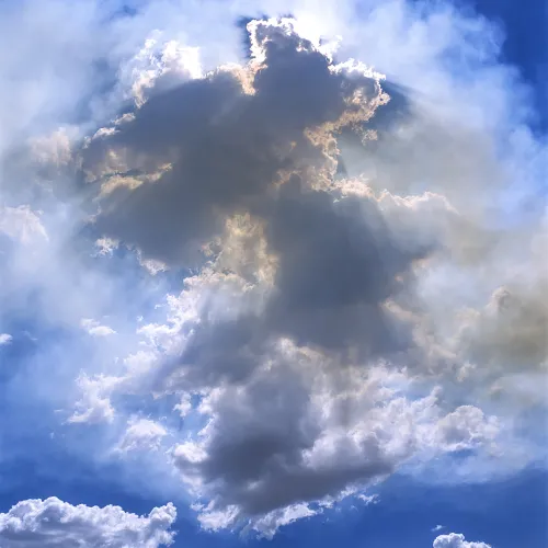 Image of sunlight behind a cloud against a blue sky