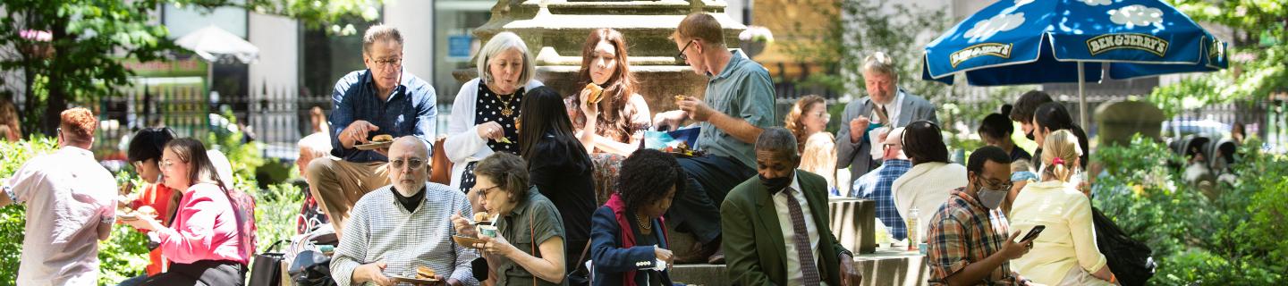 A group of parishioners enjoy lunch on the steps of the Soldiers' Monument in the northeast corner of Trinity Churchyard during a Spring 2022 Celebration.