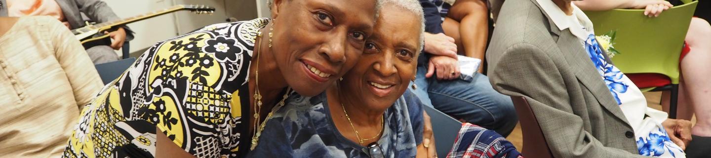 Two seniors smile at the camera